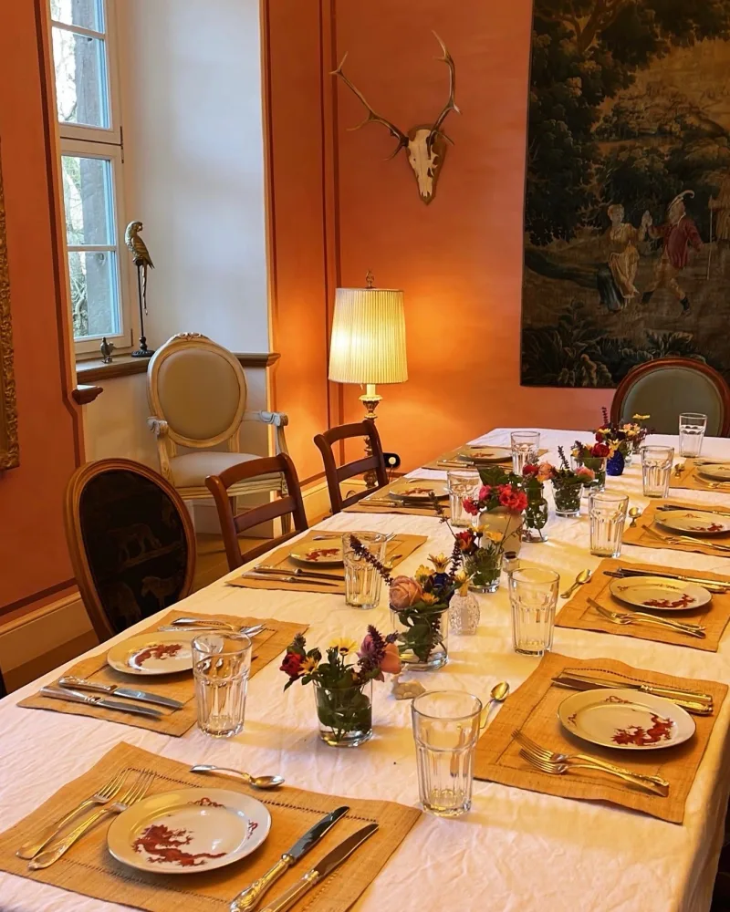 Eingedeckte Tafel im orangefarbenen Salon von Schloss Bündorf