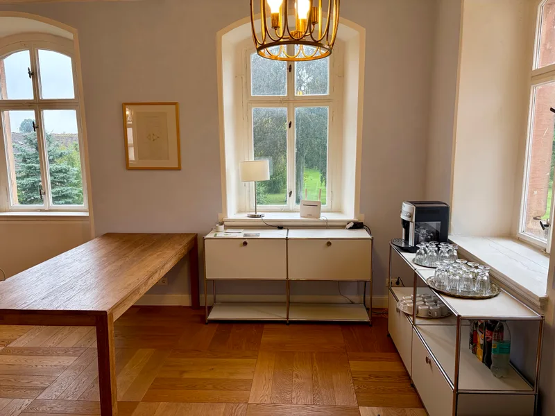 Pavillon von Schloss Bündorf mit Stuckdecke, Lounge-Sesseln, Bildschirm und Stuhlreihen