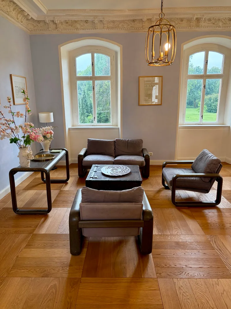 Lounge mit Sesseln im barocken Pavillon von Schloss Bündorf mit Blick in den Park