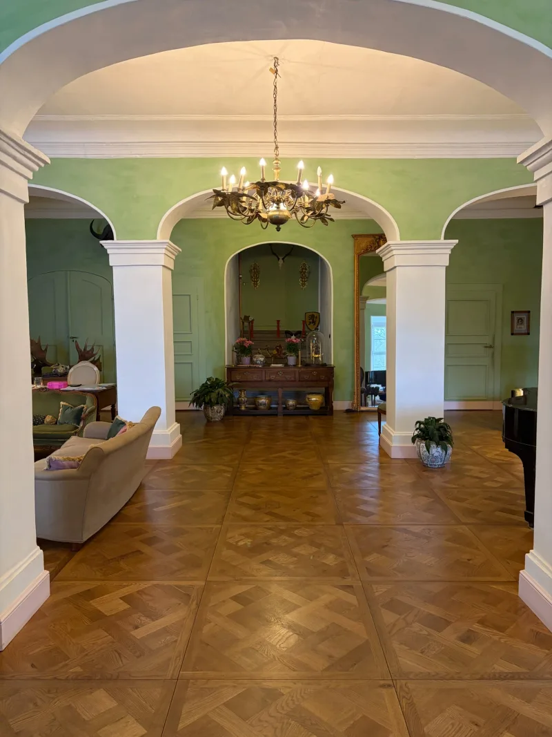 Schlosssaal von Schloss Bündorf mit Säulenbögen, Kronleuchter und Parkett