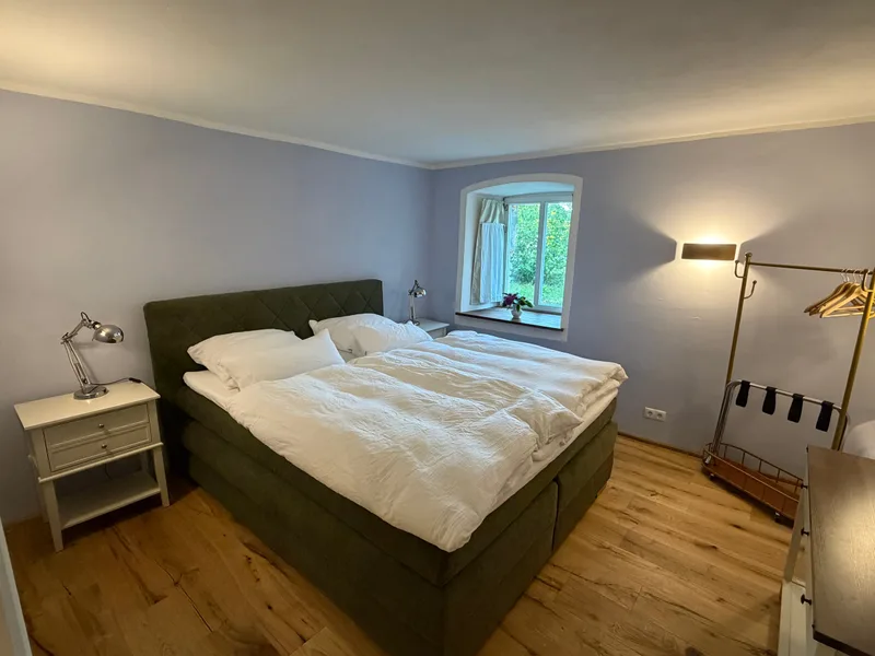 Doppelzimmer Seezimmer mit Boxspringbett, Holzdielen und Fenster ins Grüne, Übernachtung auf Schloss Bündorf